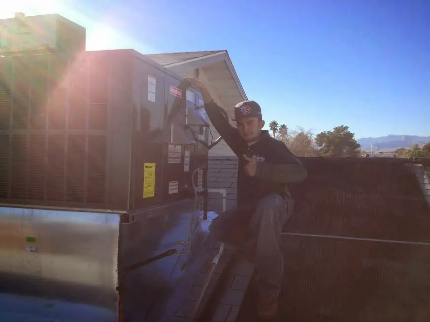 HVAC technician performing Air Duct Cleaning on a rooftop unit in Crestwood